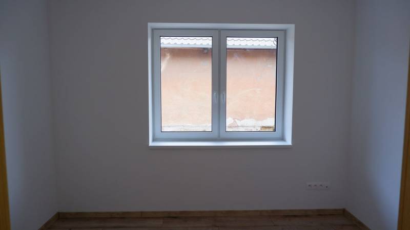 Ponúkame na predaj 4izb rodinný dom v štandarde v obci Radava - Miestnosť v rodinnom dome s veľkým oknom a podlahou s dreveným dekorom.