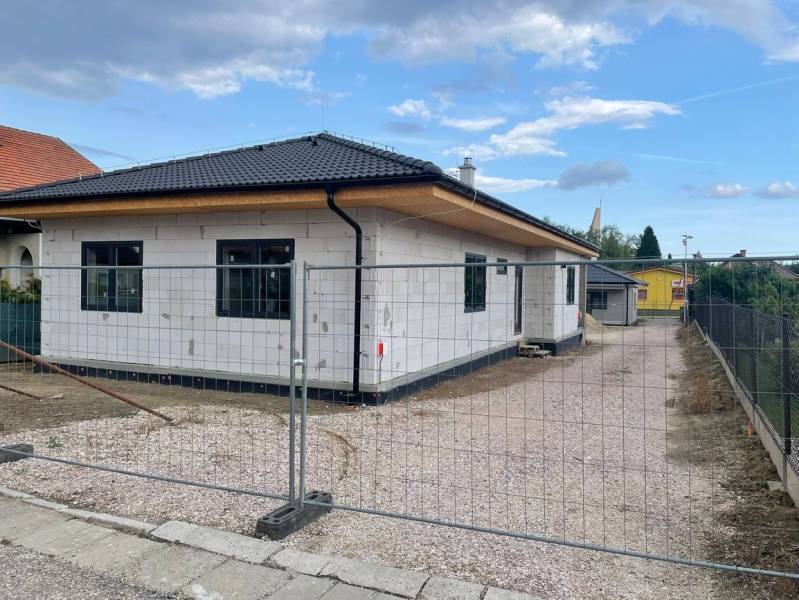 Ponúkame na predaj štvorizbový rodinný dom v obci Radava. - V Radave prebieha výstavba rodinného domu so šikmou strechou a bielou fasádou.