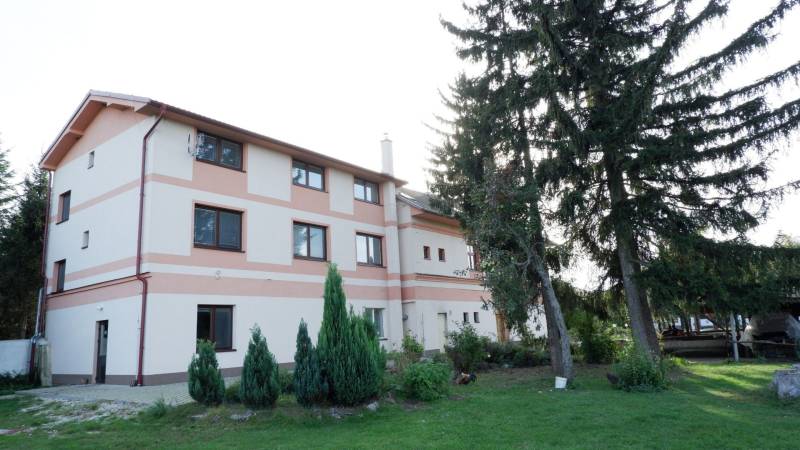 Ponúkame na predaj penzión v Poľnom Kesove - Budova hotela a penziónu v Poľnom Kesove obklopená zeleňou a stromami.