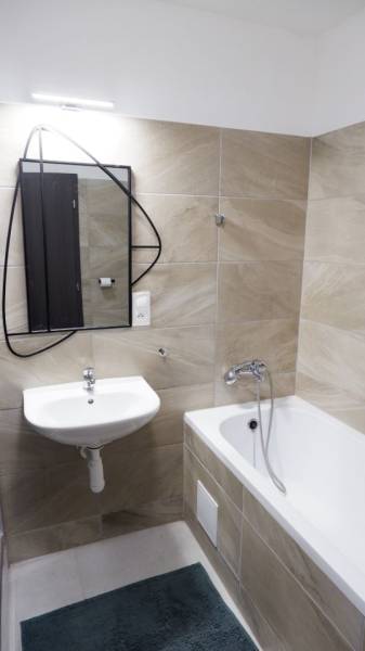 Ponúkame na predaj 3 izbový radový dom v obci Rastislavice. - Kúpeľňa s vaňou, umývadlom a zrkadlom, s obkladmi v pieskových odtieňoch.