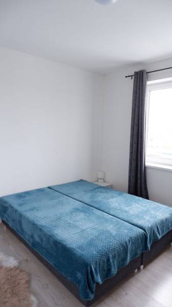 Ponúkame na predaj 3 izbový radový dom v obci Rastislavice. - Spálňa v rodinnom dome s modrými prehozmi na posteli a roletami.