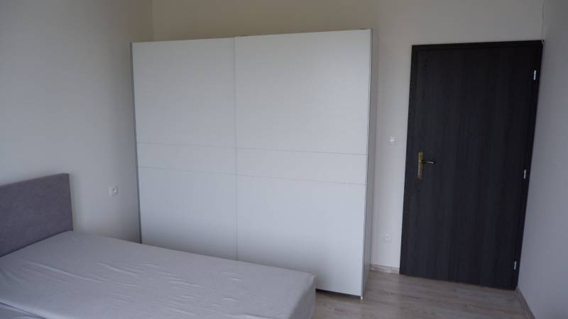 Ponúkame na predaj 3 izbový radový dom v obci Rastislavice. - Izba rodinného domu s posteľou, bielou skriňou a tmavými dverami.