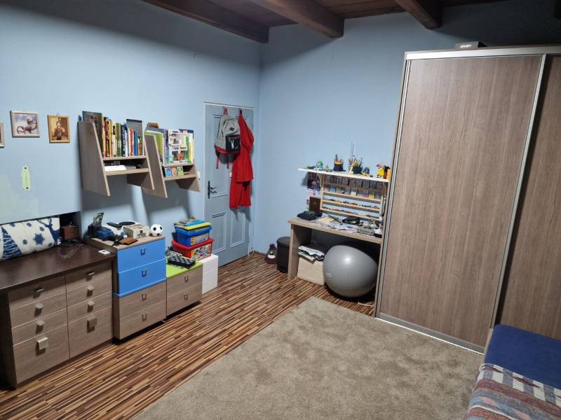 Krásny rodinný dom s rozľahlým pozemkom - Detská izba v rodinnom dome s dreveným dekorom a nábytkom.