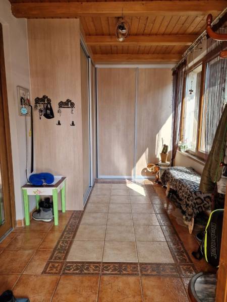 Krásny rodinný dom s rozľahlým pozemkom - Chodba s dlažbou, vstavanou skriňou a lavicou v rodinnom dome.