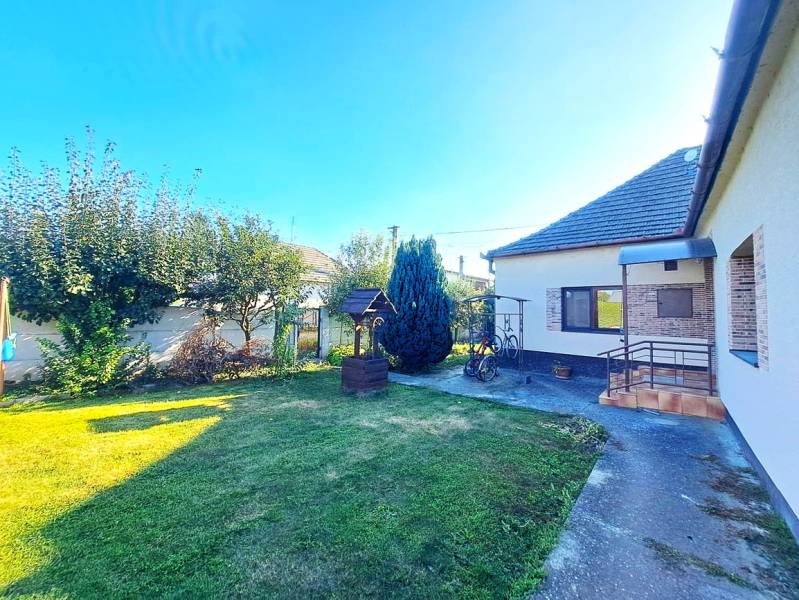 Domov, kde si vytvoríte vlastný príbeh – rodinný dom na predaj, Neded - Rodinný dom v Nedede s upravenou záhradou, trávnikom a altánkom vedľa domu.