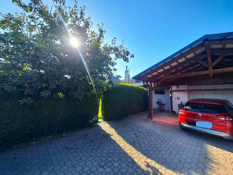 Domov, kde si vytvoríte vlastný príbeh – rodinný dom na predaj, Neded - Rodinný dom v Nedede s červeným autom pred garážou, slnečný deň a strom.