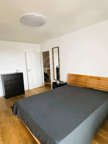 5 - izbový rodinný dom - 168 m², na pozemku 223 m², Ivanka pri Dunaji - Spálňa v rodinnom dome s posteľou, komodou a podlahou s dreveným dekorom.