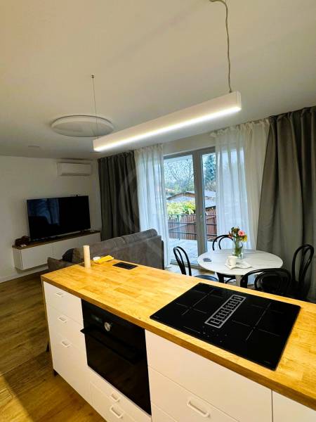 5 - izbový rodinný dom - 168 m², na pozemku 223 m², Ivanka pri Dunaji - Kuchynský ostrovček s varnou doskou, jedálenský stôl a pohovka v rodinnom dome.