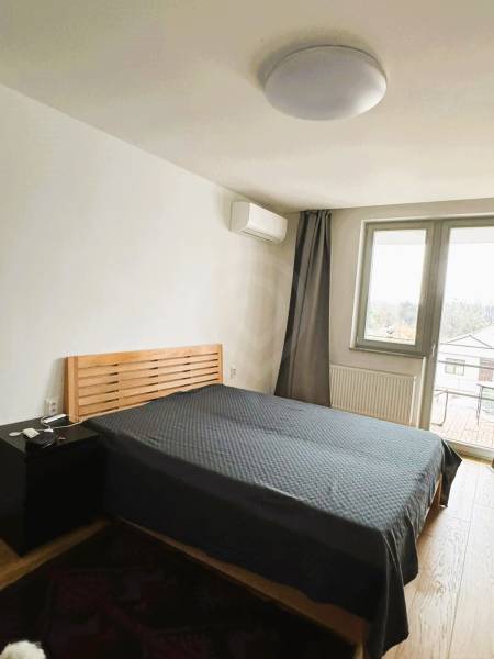 5 - izbový rodinný dom - 168 m², na pozemku 223 m², Ivanka pri Dunaji - Spálňa s posteľou, nočným stolíkom a podlahou s dreveným dekorom v Rodinnom dome.