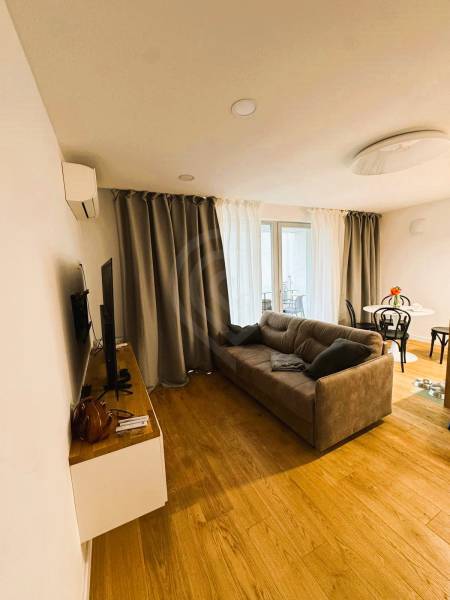 5 - izbový rodinný dom - 168 m², na pozemku 223 m², Ivanka pri Dunaji - Obývacia izba v rodinnom dome s podlahou s dreveným dekorom, sivou sedačkou a závesmi.