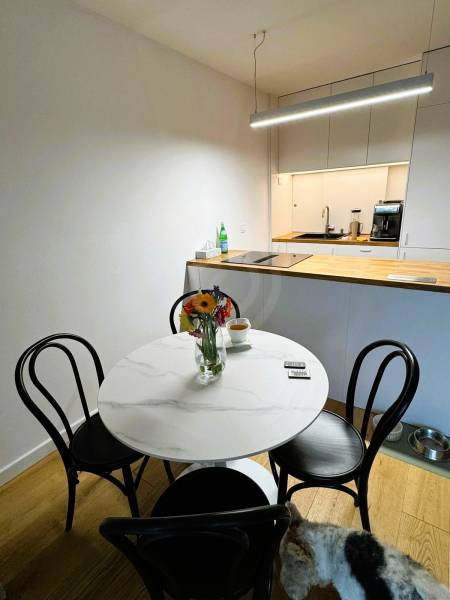 5 - izbový rodinný dom - 168 m², na pozemku 223 m², Ivanka pri Dunaji - Jedáleň v rodinnom dome s okrúhlym stolom, kvetmi a podlahou s dreveným dekorom.