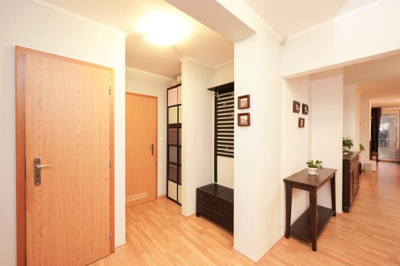 ViNi real / TOP PONUKA! Moderný 4-izb. bungalov s garážou, KVETOSLAVOV - Interiér rodinného domu s podlahou s dreveným dekorom, farebnými skrinkami a kvetináčom.