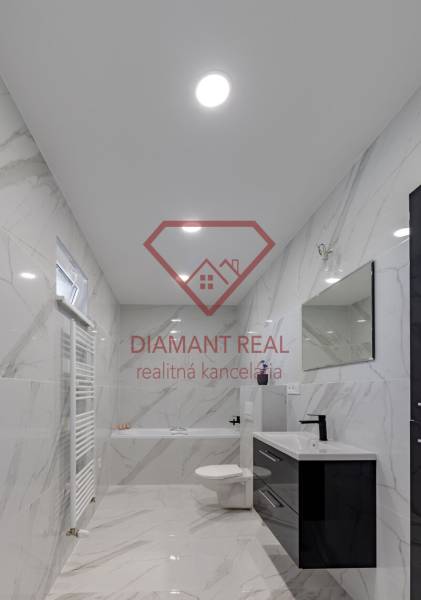 5 i nadštandardný rodinný dom s výhľadom na jazero - Trnovec n/Váhom  - Kúpeľňa v rodinnom dome s keramickými stenami a vaňou, čiernym umývadlom a zrkadlom.