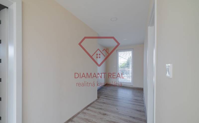 5 i nadštandardný rodinný dom s výhľadom na jazero - Trnovec n/Váhom  - Chodba v rodinnom dome s podlahou s dreveným dekorom a veľkým oknom.