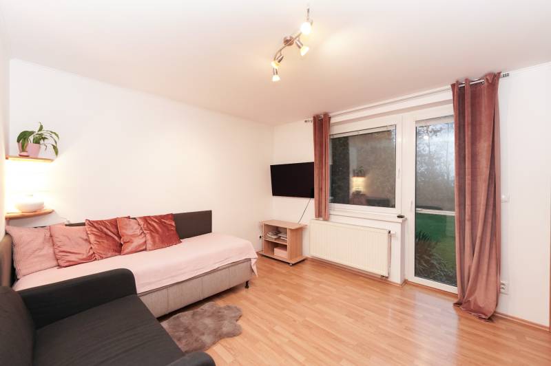 Investičná príležitosť v Kvetoslavov - DOM ideálny pre súkromnú škôlku - Obývacia izba v rodinnom dome s pohovkou, televízorom a podlahou s dreveným dekorom.