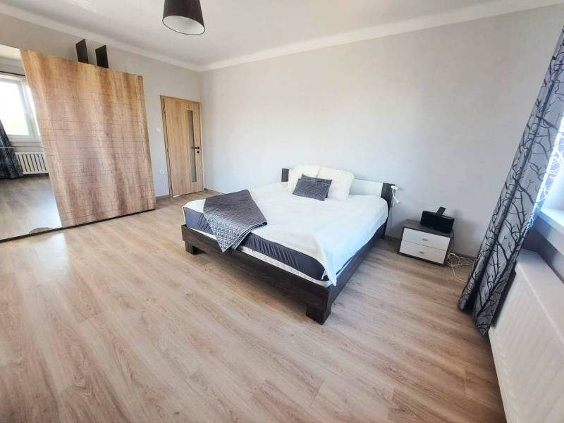 Exkluzívne na predaj 5 izbový rodinný dom - Spálňa v rodinnom dome s posteľou, šatníkovou skriňou a podlahou s dreveným dekorom.