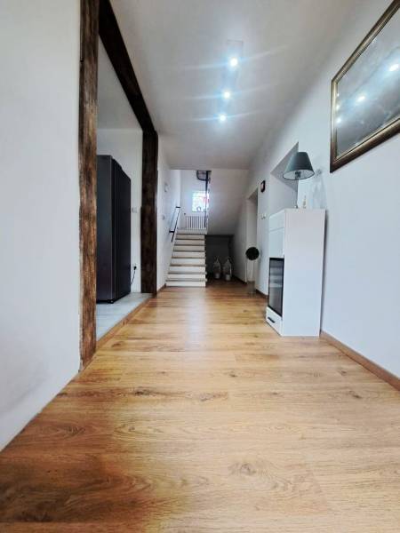 Exkluzívne na predaj 5 izbový rodinný dom - Interiér rodinného domu s podlahou s dreveným dekorom a schodiskom v pozadí.