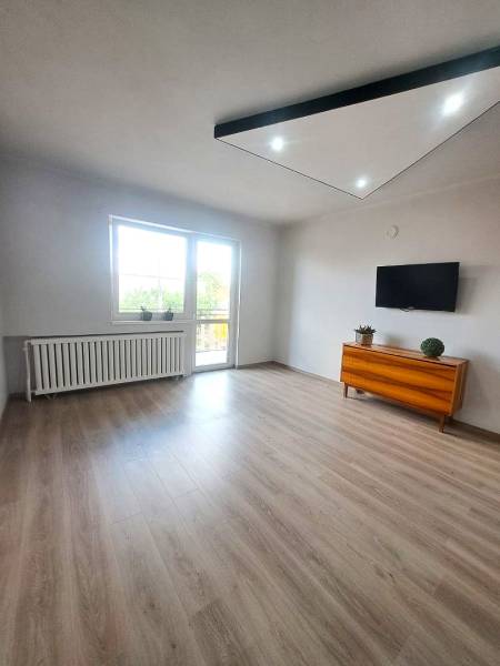 Exkluzívne na predaj 5 izbový rodinný dom - Obývačka v rodinnom dome s podlahou s dreveným dekorom, televíziou a komodou.