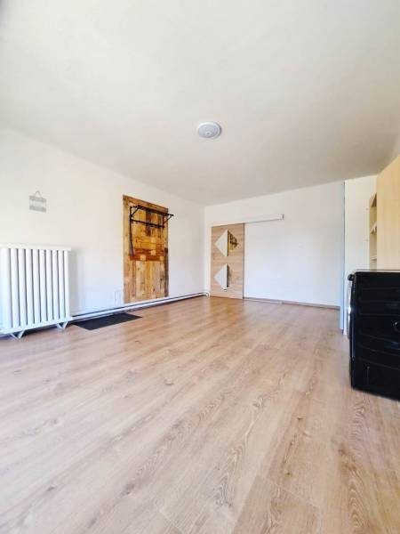 Exkluzívne na predaj 5 izbový rodinný dom - Interiér rodinného domu s podlahou s dreveným dekorom a bielymi stenami.