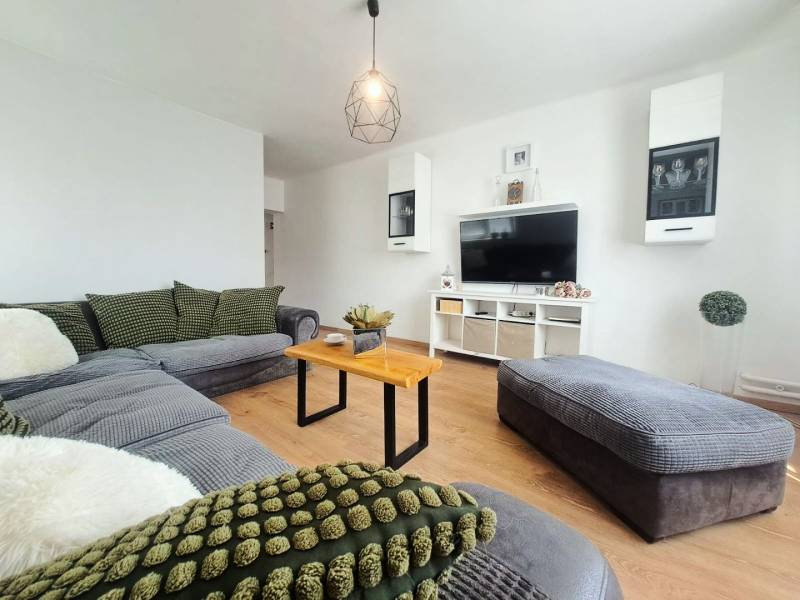 Exkluzívne na predaj 5 izbový rodinný dom - Obývacia izba v rodinnom dome s podlahou s dreveným dekorom a pohodlnou sedacou súpravou.