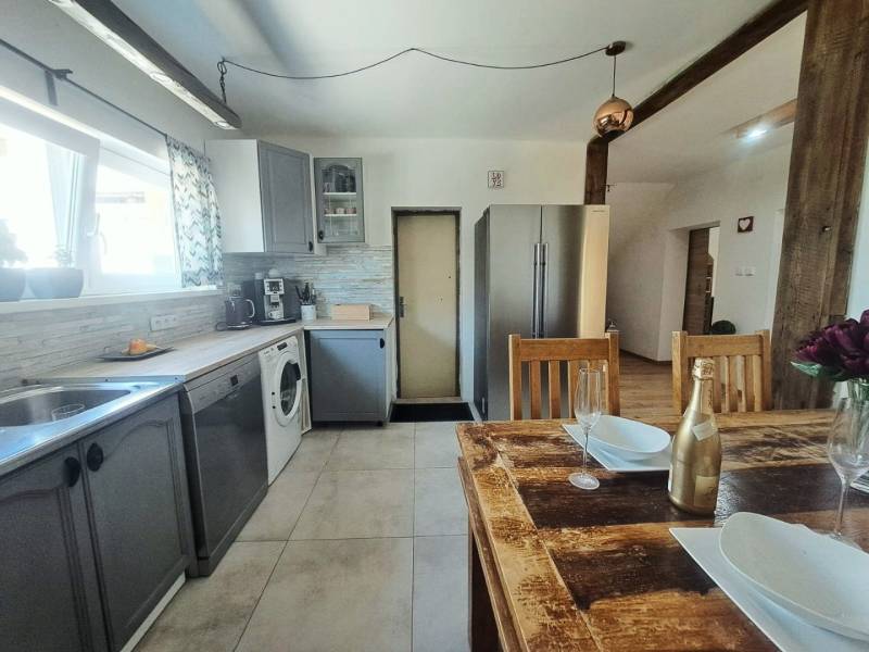 Exkluzívne na predaj 5 izbový rodinný dom - Kuchyňa v rodinnom dome s dreveným stolom a modernými spotrebičmi.