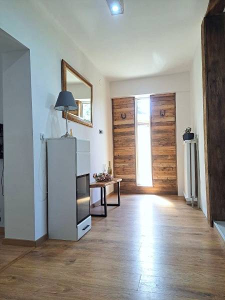 Exkluzívne na predaj 5 izbový rodinný dom - Interiér s drevenými vstupnými dverami a podlahou s dreveným dekorom v rodinnom dome.