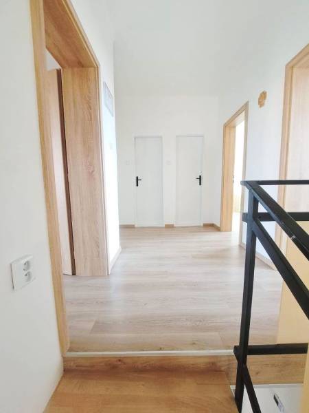 Exkluzívne na predaj 5 izbový rodinný dom - Interiér rodinného domu s podlahou s dreveným dekorom a bielymi dverami.