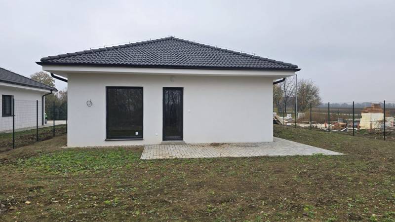 Moderný nízkoenergetický 4-izbový rodinný dom, Cífer – Karlov Dvor - Rodinný dom v Cíferi s bielou fasádou a terasou v záhrade.