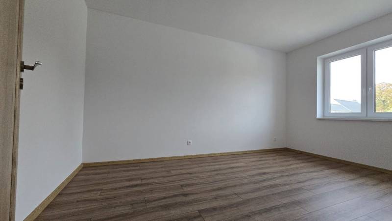 Moderný nízkoenergetický 4-izbový rodinný dom, Cífer – Karlov Dvor - Izba v rodinnom dome s podlahou s dreveným dekorom a veľkým oknom.