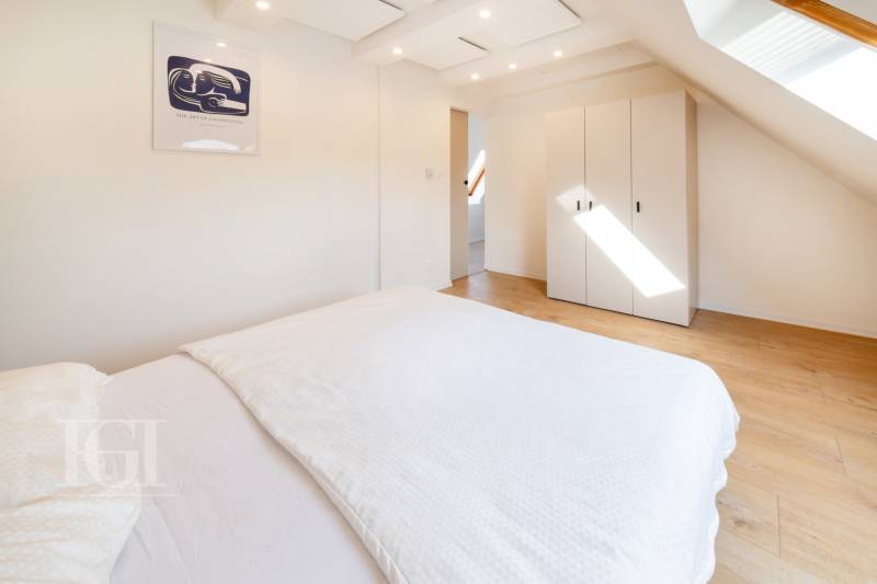  REZERVOVANY-PRENAJOM | NOVÝ 2 i. podkrovný byt v novostavbe - Spálňa s podlahou s dreveným dekorom a skriňou v 2-izbovom byte.