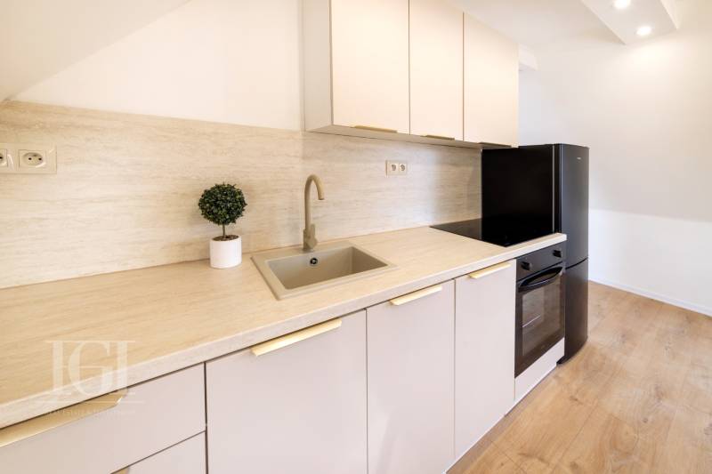  REZERVOVANY-PRENAJOM | NOVÝ 2 i. podkrovný byt v novostavbe - Kuchyňa v 2-izbovom byte s podlahou s dreveným dekorom a moderným vybavením.