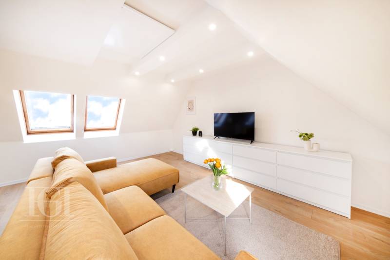  REZERVOVANY-PRENAJOM | NOVÝ 2 i. podkrovný byt v novostavbe - Obývačka v 2-izbovom byte s béžovou sedačkou, bielym nábytkom a podlahou s dreveným dekorom.