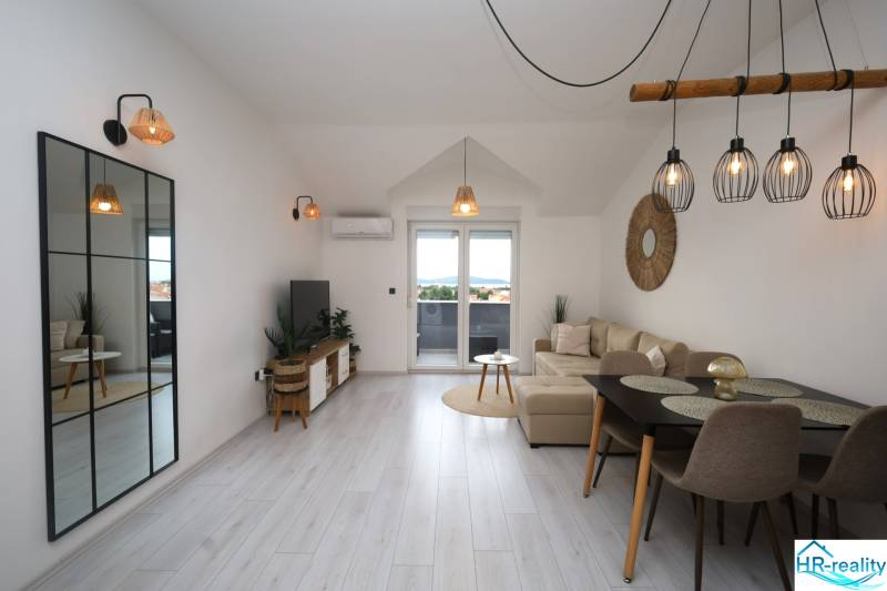 Vodice – novo zrekonštruovaný dvojspálňový apartmán s výhľadom na more - Obývacia izba v Rekreačnom apartmáne s podlahou s dreveným dekorom a veľkým zrkadlom.