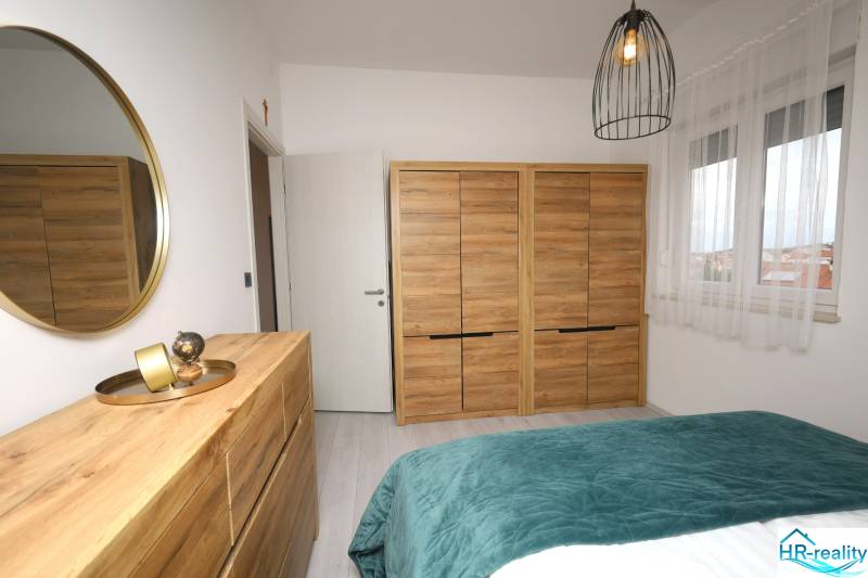Vodice – novo zrekonštruovaný dvojspálňový apartmán s výhľadom na more - Spálňa v Rekreačnom apartmáne s dreveným dekorom, zrkadlom a dekoráciami.