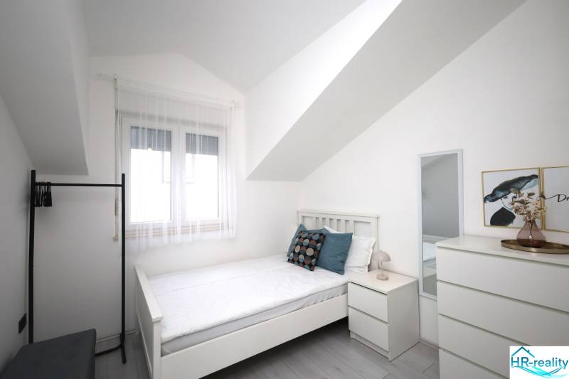 Vodice – novo zrekonštruovaný dvojspálňový apartmán s výhľadom na more - Svetlá izba s posteľou, zrkadlom a dekoráciami v Rekreačnom apartmáne.