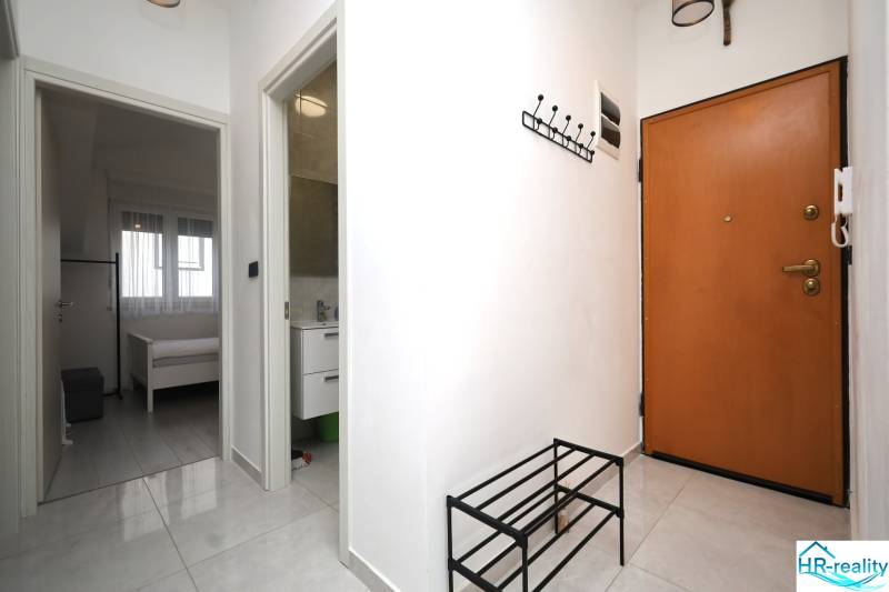 Vodice – novo zrekonštruovaný dvojspálňový apartmán s výhľadom na more - Rekreačný apartmán s dlažbou, vešiakom, otvorenými dverami do spálne a kúpeľne.