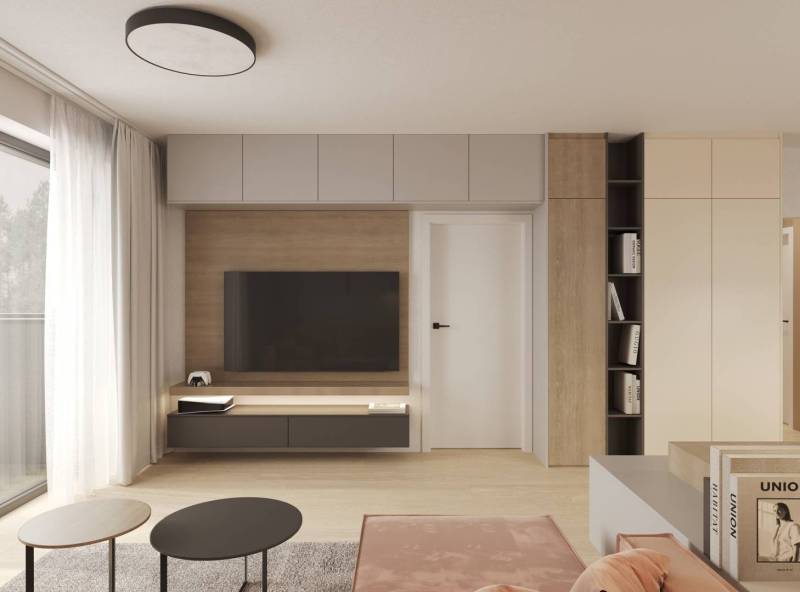 Prémiové byty s vysokým investičným potenciálom - Obývačka s TV, podlaha s dreveným dekorom, svetlé závesy, nábytok a knižnica.