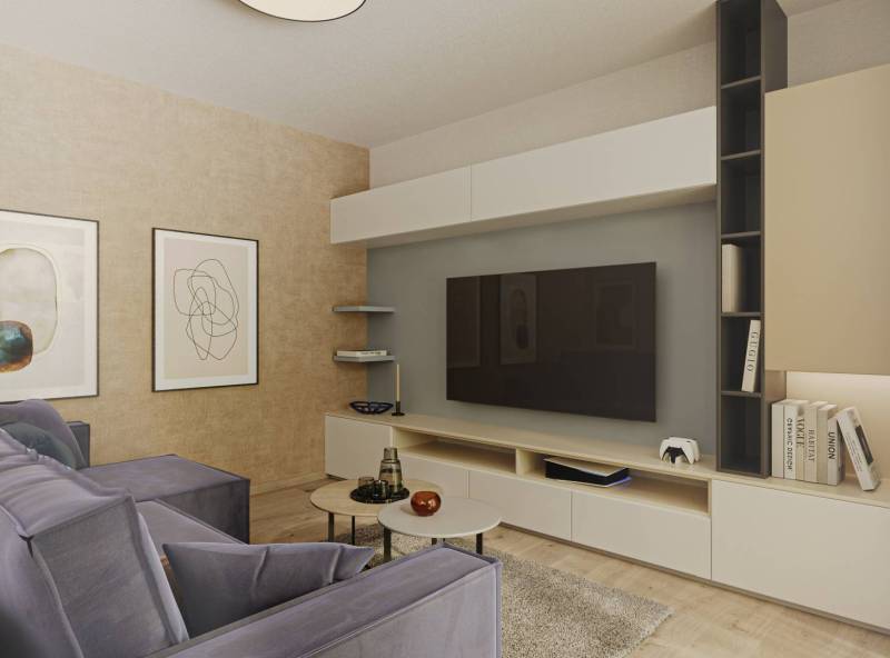 Prémiové byty s vysokým investičným potenciálom - Interiér obývačky s pohodlným gaučom, televíziou, obrazmi a podlahou s dreveným dekorom.