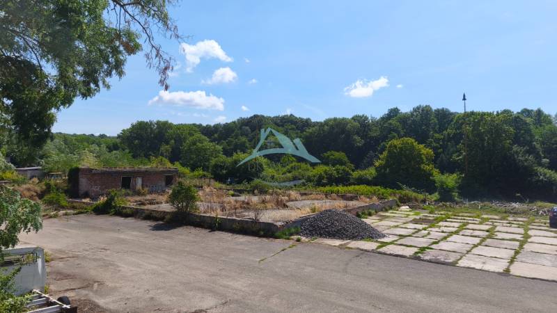 Pozemok o rozlohe 1880 m2  vo Veľkom Krtíši. - Pozemky - komerčné na Lučeneckej ceste vo Veľkom Krtíši s opustenou stavbou, obklopené stromami.