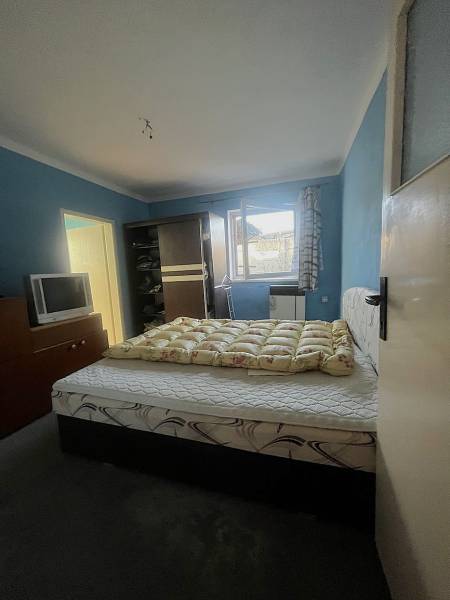 Znížená cena  4-izbový rodinný dom s veľkým pozemkom len 5min od Šale - Spálňa s posteľou, tmavým šatníkom, televízorom a modrými stenami v rodinnom dome.