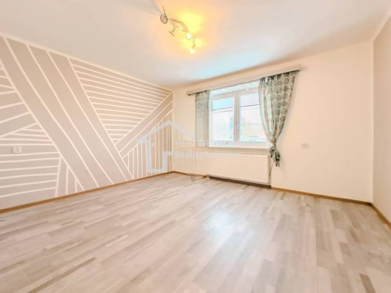 Rodinný dom vo vyhľadávanej obci Betliar. - Izba v rodinnom dome s geometrickou maľbou a podlahou s dreveným dekorom.