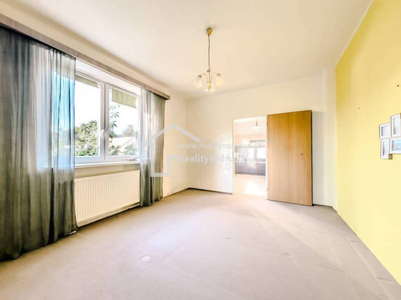 Rodinný dom vo vyhľadávanej obci Betliar. - Izba s veľkým oknom, radiátorom a prechodom v rodinnom dome.