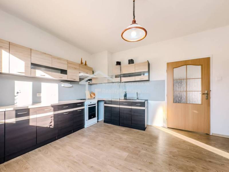 Rodinný dom vo vyhľadávanej obci Betliar. - Kuchyňa v rodinnom dome s podlahou s dreveným dekorom a modernými linkami.