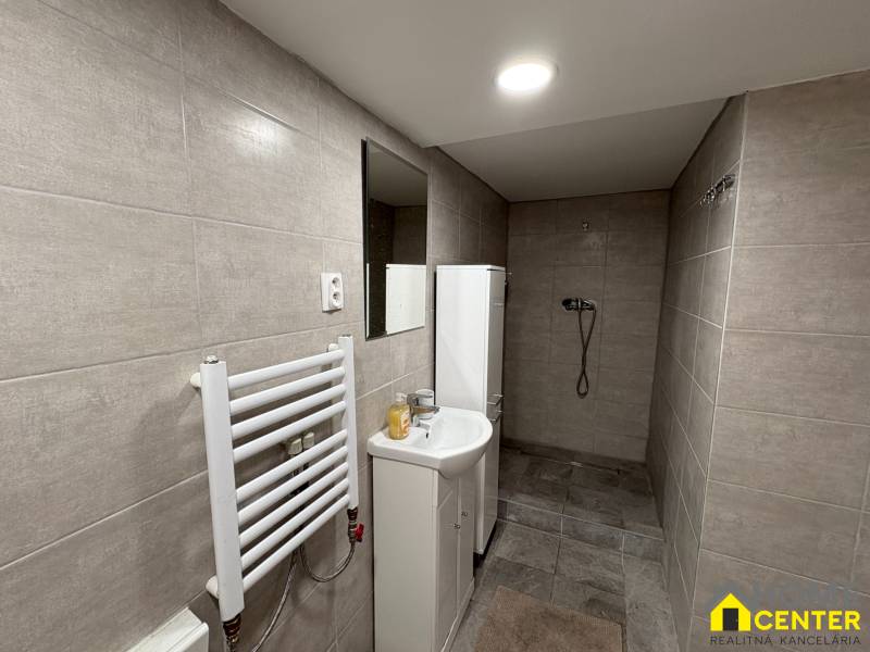 NA PRENÁJOM krásny 1 izbový apartmán so záhradou v srdci Komárna - Kúpeľňa v 1-izbovom byte s obkladmi vo svetlých odtieňoch a sprchovým kútom.