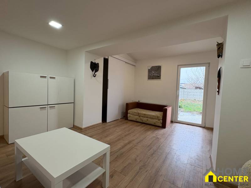 NA PRENÁJOM krásny 1 izbový apartmán so záhradou v srdci Komárna - Obývacia izba v 1-izbovom byte s nábytkom a podlahou s dreveným dekorom.