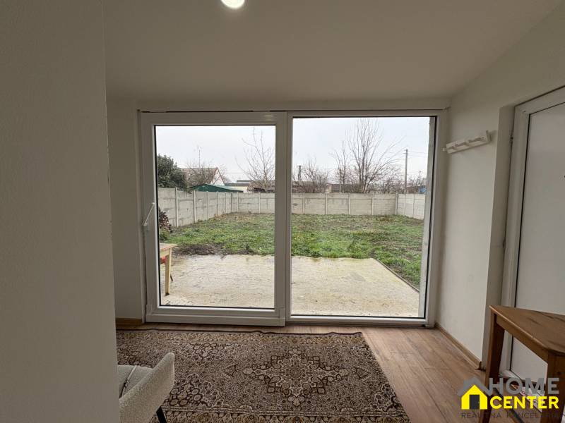 NA PRENÁJOM krásny 1 izbový apartmán so záhradou v srdci Komárna - Izba 1-izbového bytu s pohľadom na záhradu a podlahou s dreveným dekorom.