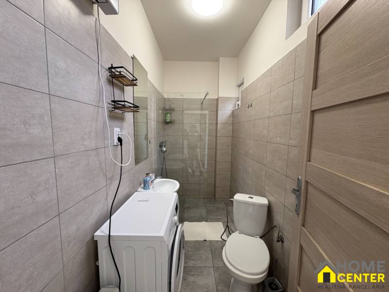 EXKLUZÍVNE na prenájom apartmán s nádychom afrického štýlu v centre KN - Kúpeľňa v 1-izbovom byte s práčkou, umývadlom a sprchovým kútom v neutrálnych odtieňoch.