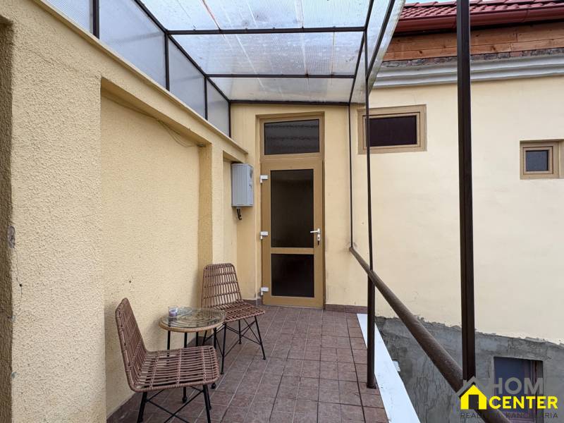 EXKLUZÍVNE na prenájom apartmán s nádychom afrického štýlu v centre KN - Kryté patio s dvoma stoličkami a stolíkom pred vstupom do 1-izbového bytu.