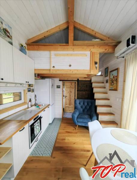 Tiny house - malý domček - Štýlová kuchyňa so sedacím kútom v rodinnom dome s podlahou s dreveným dekorom.