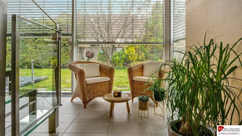 Predaj moderná 5 izbová vila, 265 m2, pozemok 953 m2, bazén,BA II. - Príjemný kútik na oddych s ratanovými kreslami, stolíkom a výhľadom do záhrady.